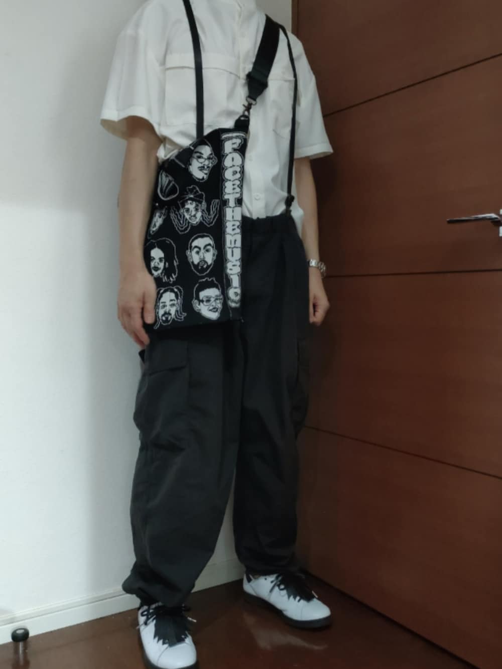 ホワイト系のスニーカー、ブラック系のカーゴパンツを着用したメンズの夏コーディネートの3枚目の写真