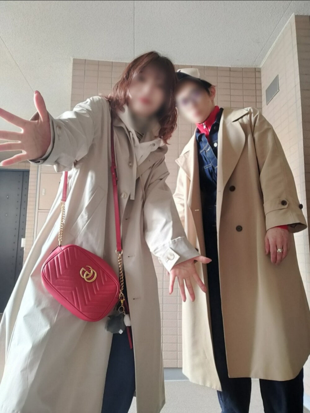 ベージュ系のトレンチコート、ブルー系のデニムジャケット、レッド系のジャージを着用したメンズの春コーディネートの2枚目の写真