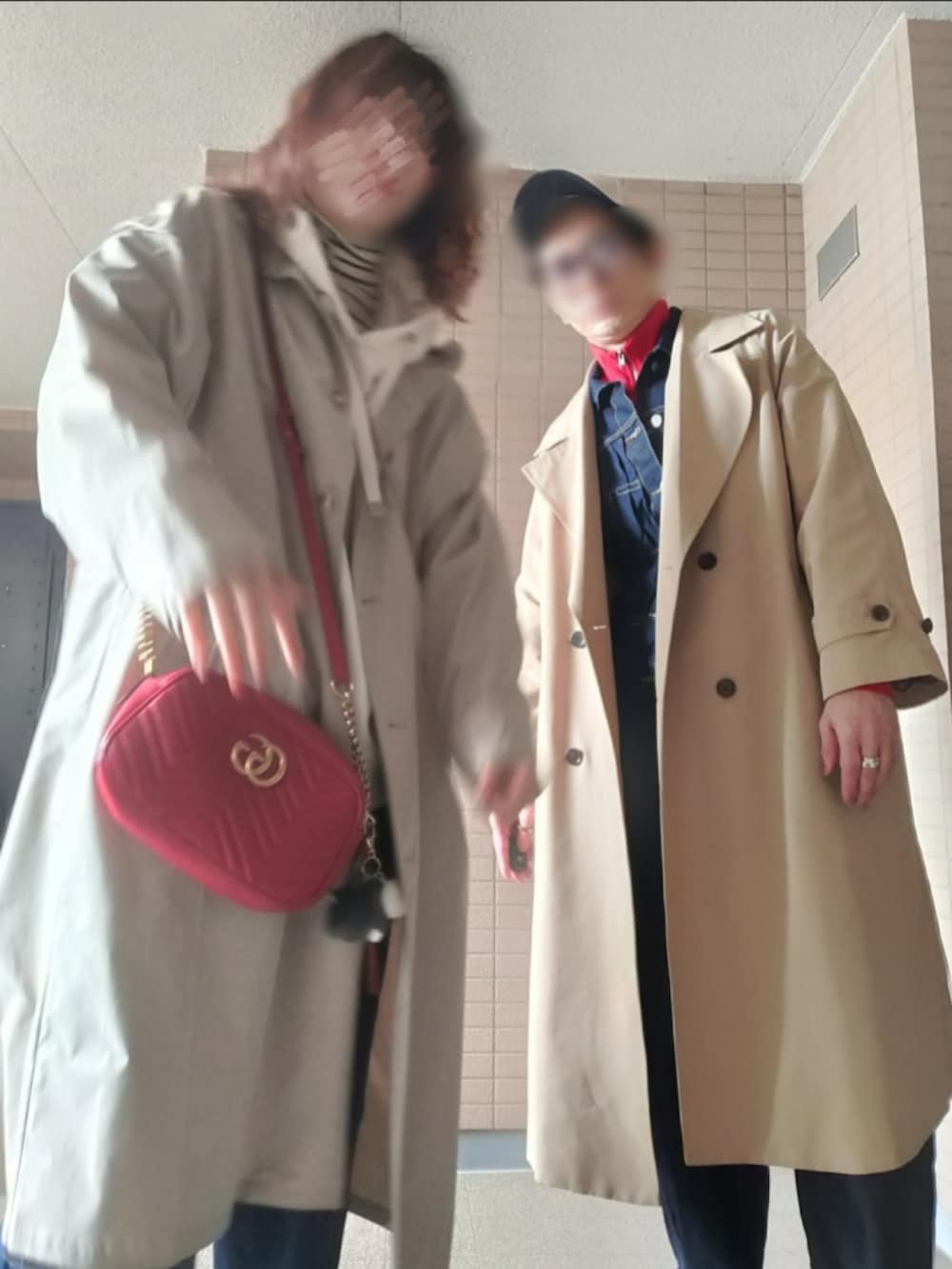 ベージュ系のトレンチコート、ブルー系のデニムジャケット、レッド系のジャージを着用したメンズの春コーディネートの3枚目の写真