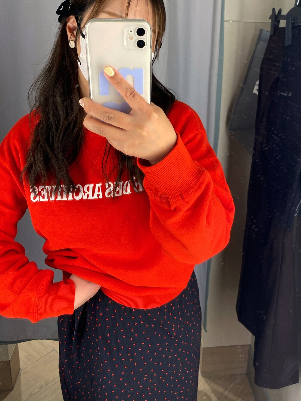 レッド系のスウェット、ブラック系のワンピースを着用したレディースの春コーディネートの2枚目の写真