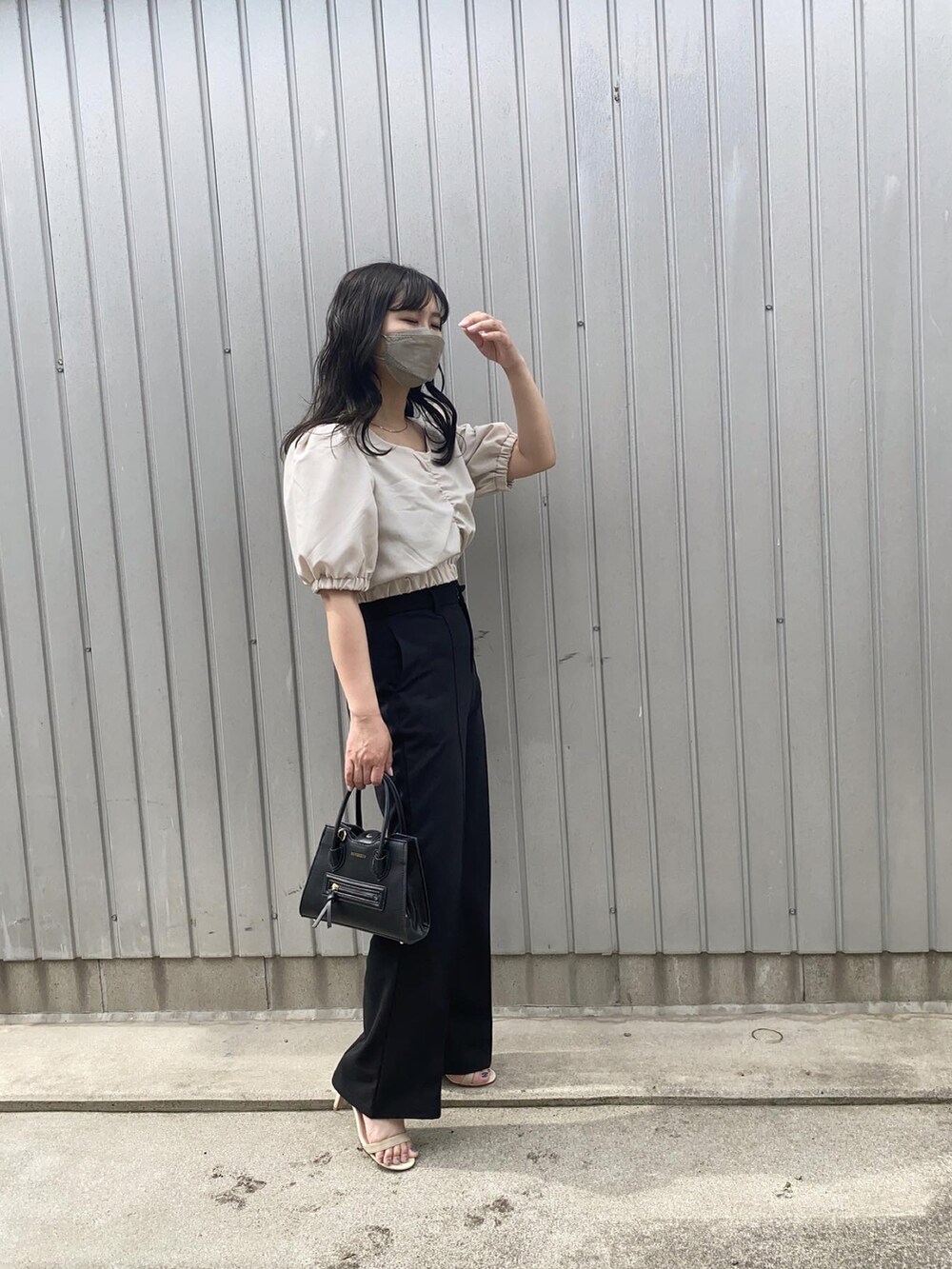 ベージュ系のシャツ/ブラウス、ブラック系のショルダーバッグ、ブラック系のスラックスを着用したレディースの春コーディネートの2枚目の写真