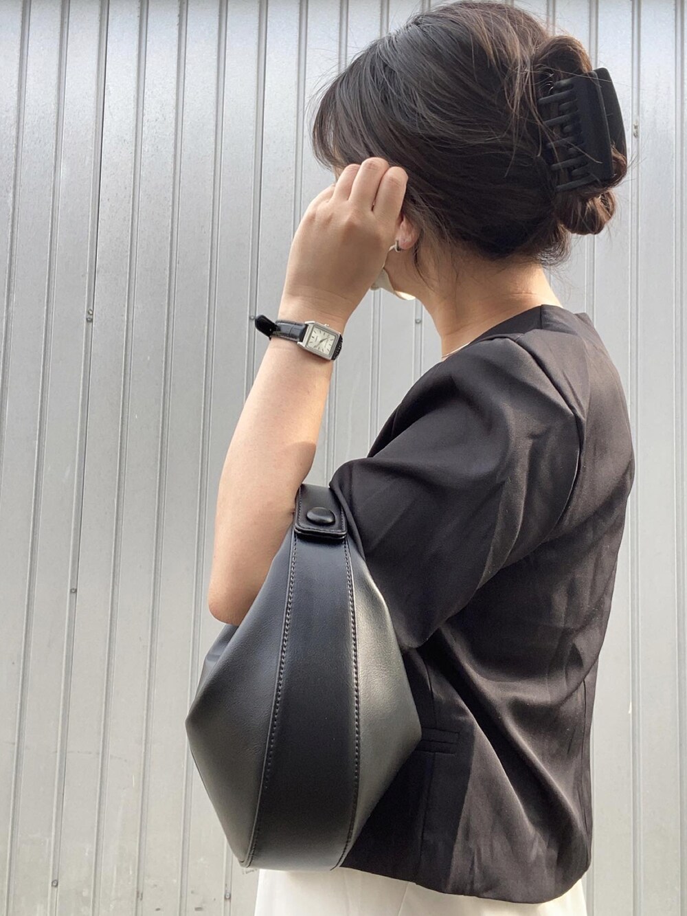 ブラック系のシャツ/ブラウス、ブラック系のハンドバッグ、ホワイト系のスカートを着用したレディースの夏コーディネートの3枚目の写真