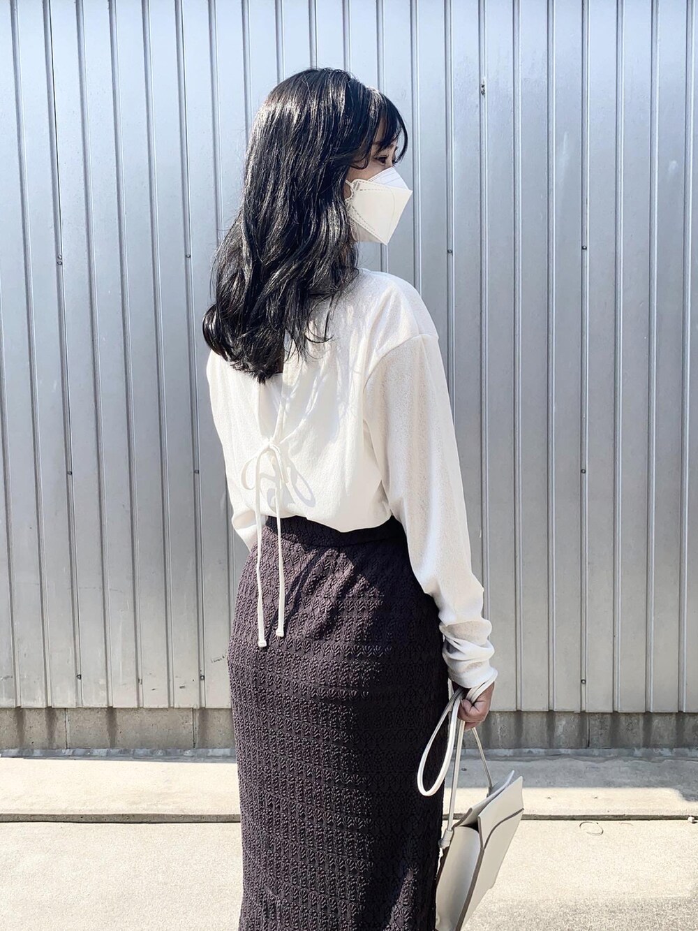 ホワイト系のTシャツ/カットソー、ブラック系のスカート、ホワイト系のサンダルを着用したレディースの春コーディネートの3枚目の写真