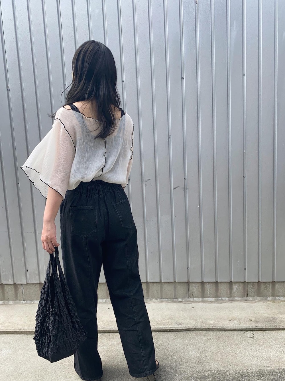 ホワイト系のTシャツ/カットソー、ブラック系のデニムパンツ、ブラック系のサンダルを着用したレディースの春コーディネートの2枚目の写真