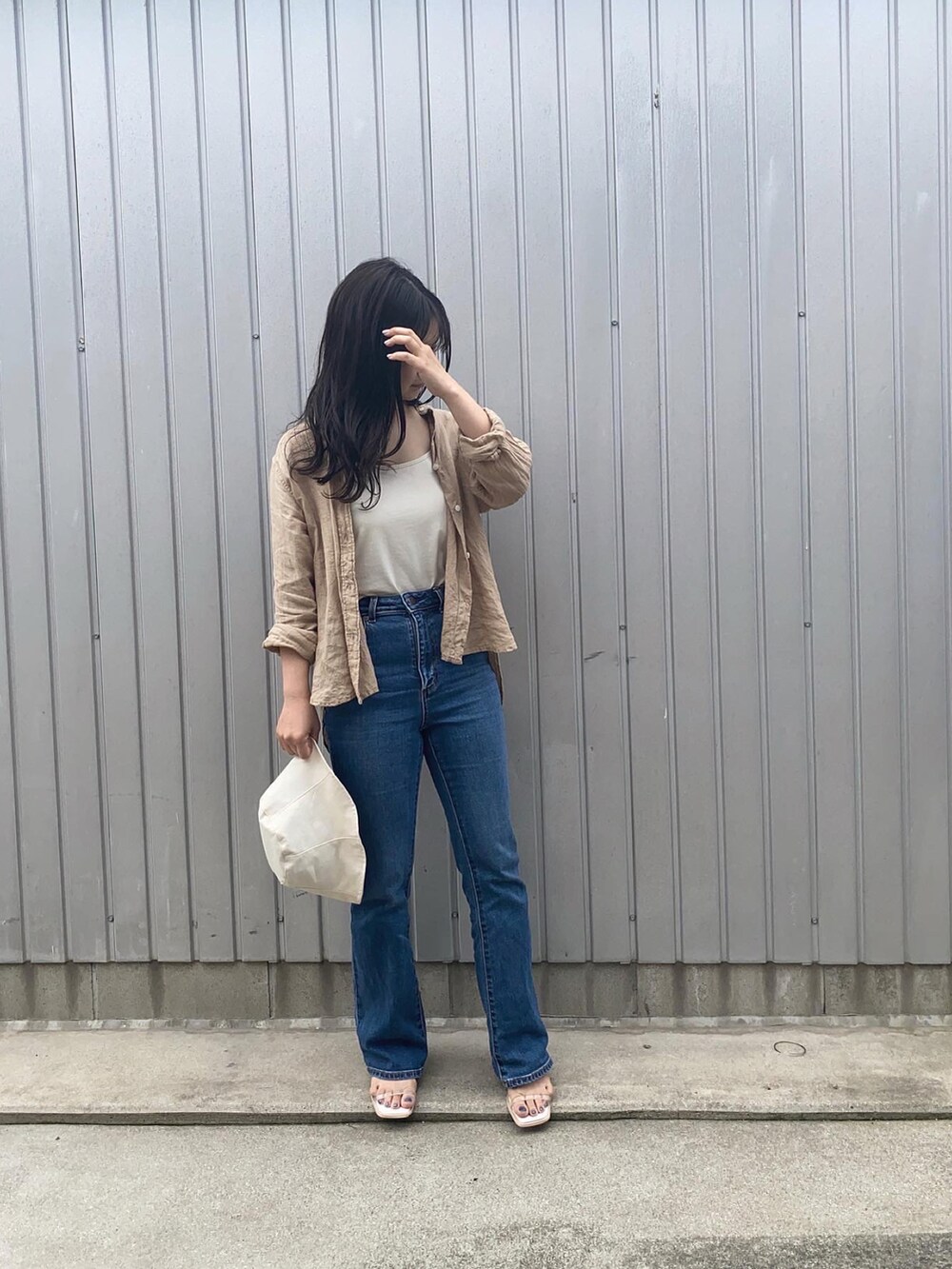 ベージュ系のシャツ/ブラウス、ホワイト系のサンダル、ブルー系のデニムパンツを着用したレディースの春コーディネートの2枚目の写真