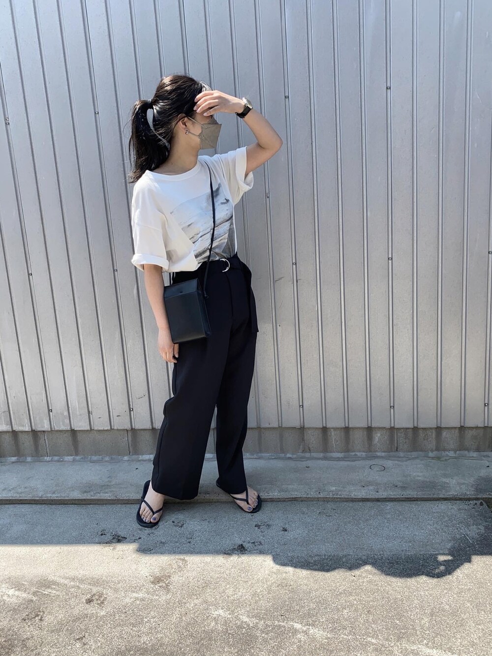 ホワイト系のTシャツ/カットソー、ブラック系のショルダーバッグ、ブラック系のサンダルを着用したレディースの春コーディネートの2枚目の写真