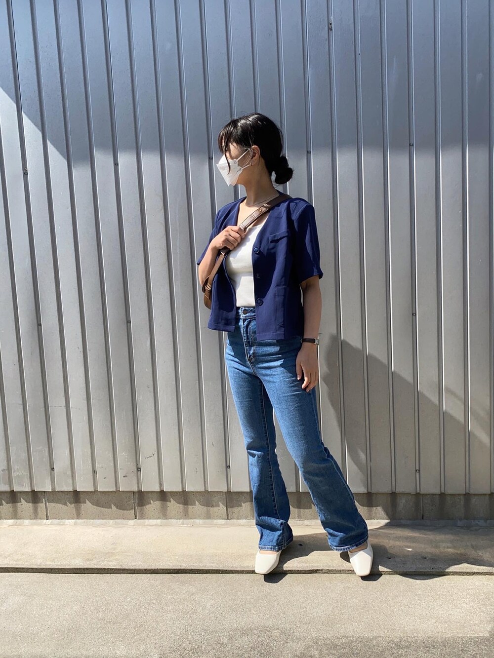 ホワイト系のサンダル、ブラウン系のショルダーバッグ、ブルー系のシャツ/ブラウスを着用したレディースの春コーディネートの2枚目の写真