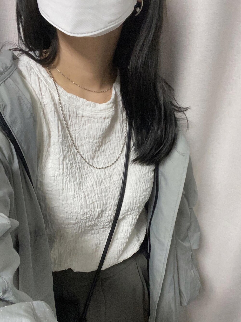 グレー系のモッズコート、ブラック系のショルダーバッグ、ホワイト系のTシャツ/カットソーを着用したレディースの春コーディネートの2枚目の写真