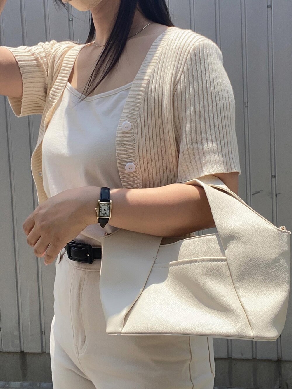 ホワイト系のハンドバッグ、ホワイト系のサンダル、イエロー系のカーディガン/ボレロを着用したレディースの夏コーディネートの2枚目の写真