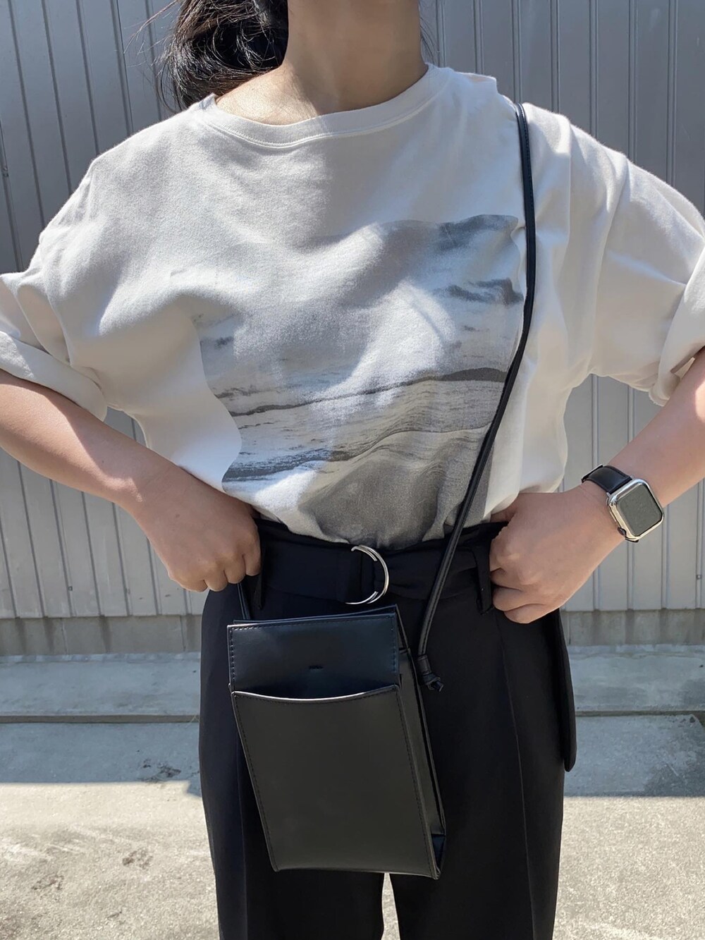 ホワイト系のTシャツ/カットソー、ブラック系のショルダーバッグ、ブラック系のサンダルを着用したレディースの春コーディネートの3枚目の写真