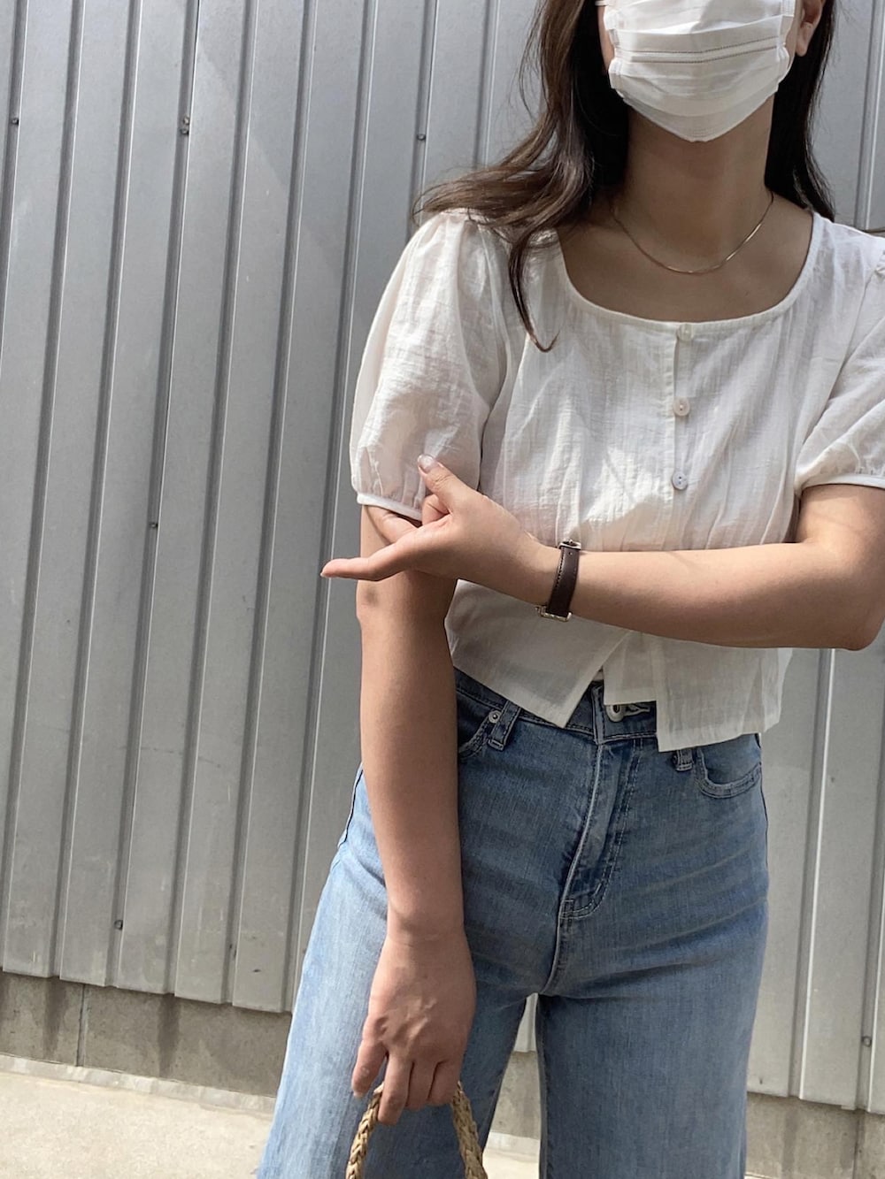 ホワイト系のサンダル、ブラウン系のかごバッグ、ホワイト系のシャツ/ブラウスを着用したレディースの夏コーディネートの2枚目の写真