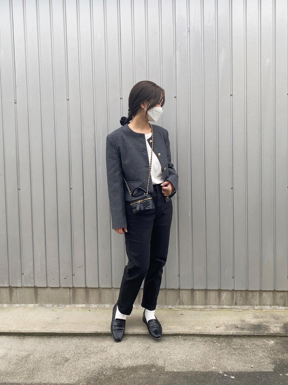 グレー系のノーカラージャケット、ブラック系のショルダーバッグ、ブラック系のデニムパンツを着用したレディースの秋コーディネートの2枚目の写真
