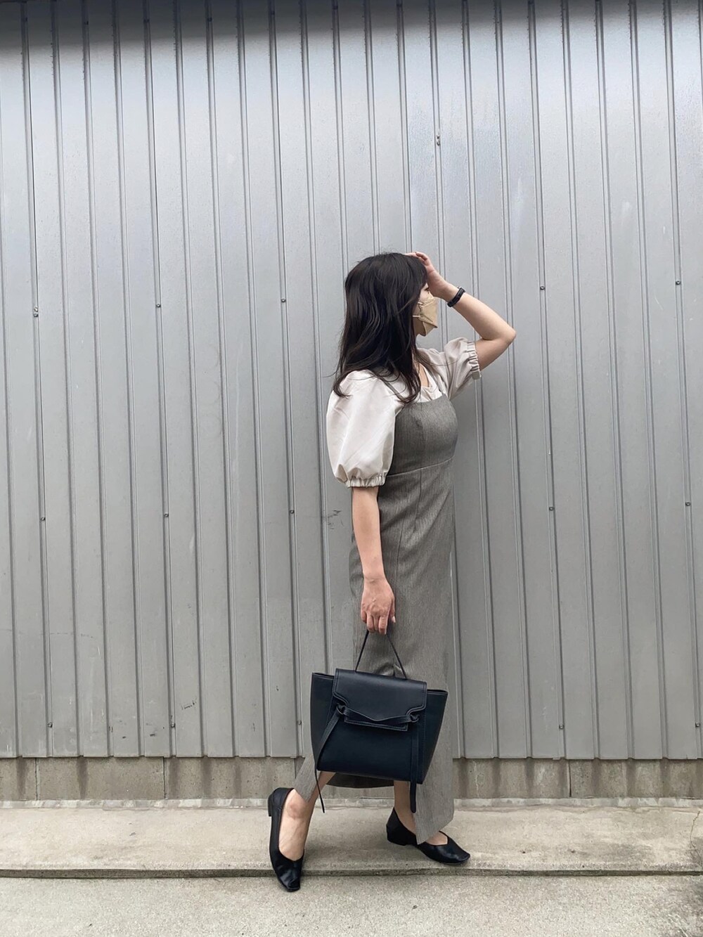 グレー系のワンピース、ブラック系のパンプス、ベージュ系のTシャツ/カットソーを着用したレディースの夏コーディネートの2枚目の写真