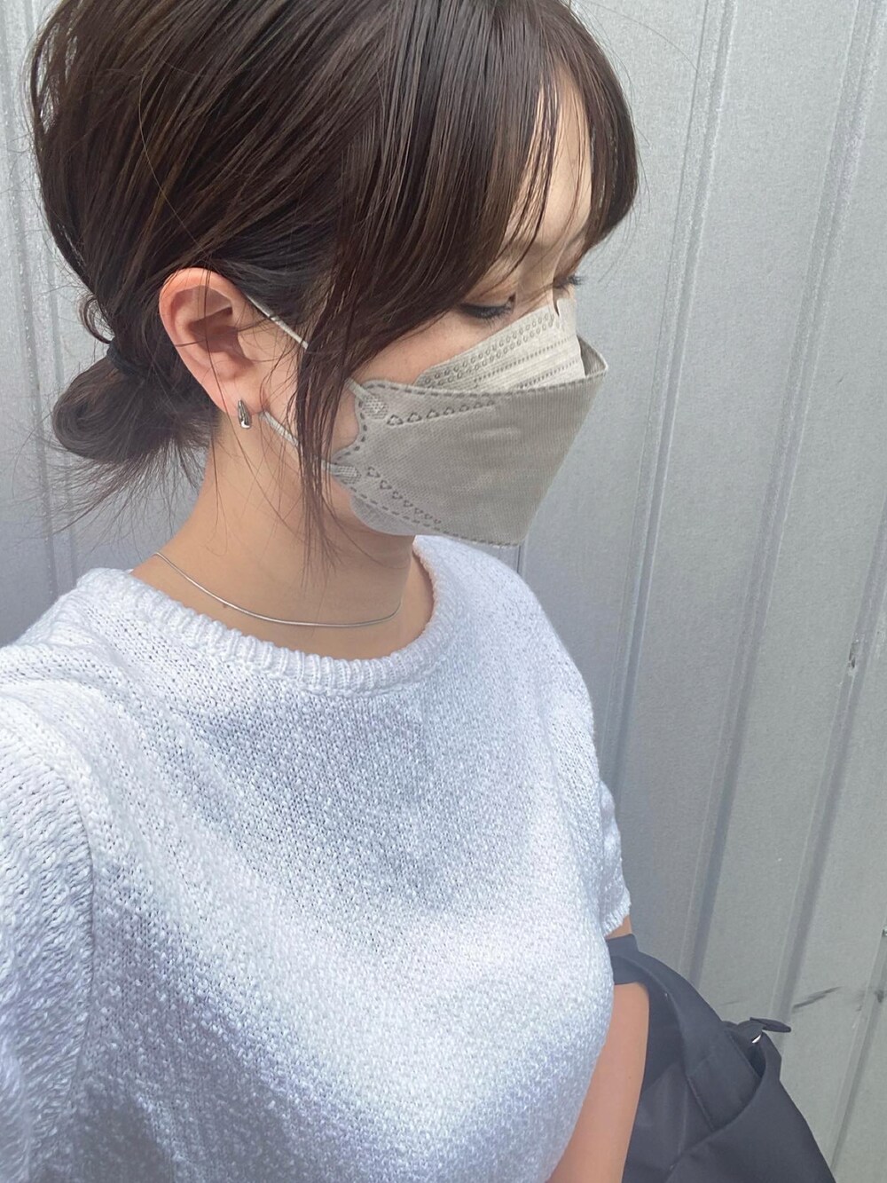 グレー系のスカート、ブラック系のトートバッグ、ホワイト系のサンダルを着用したレディースの夏コーディネートの2枚目の写真