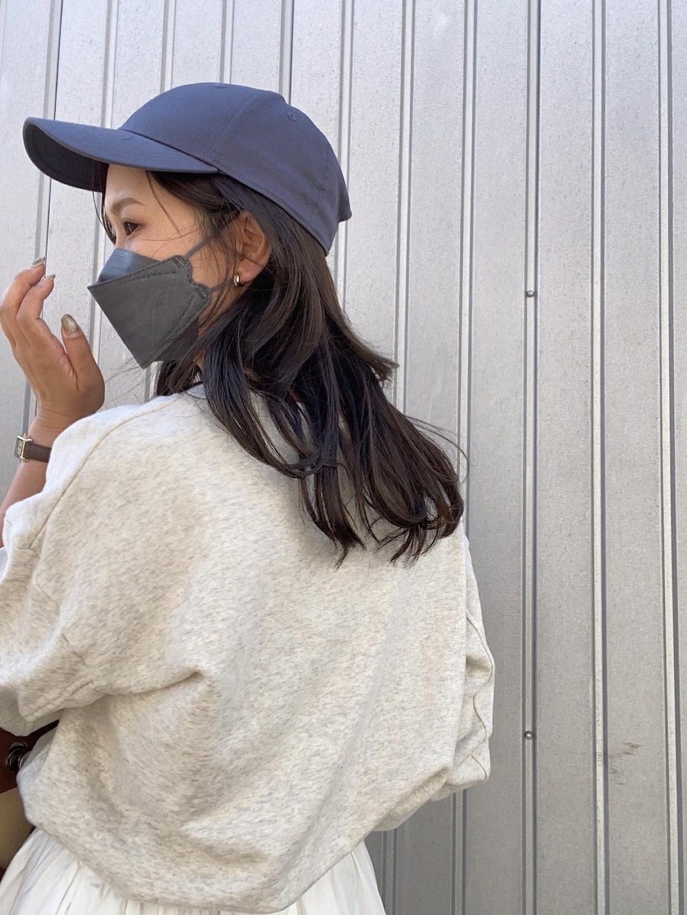 ホワイト系のスニーカー、ホワイト系のスカート、ブルー系のキャップを着用したレディースの秋コーディネートの3枚目の写真