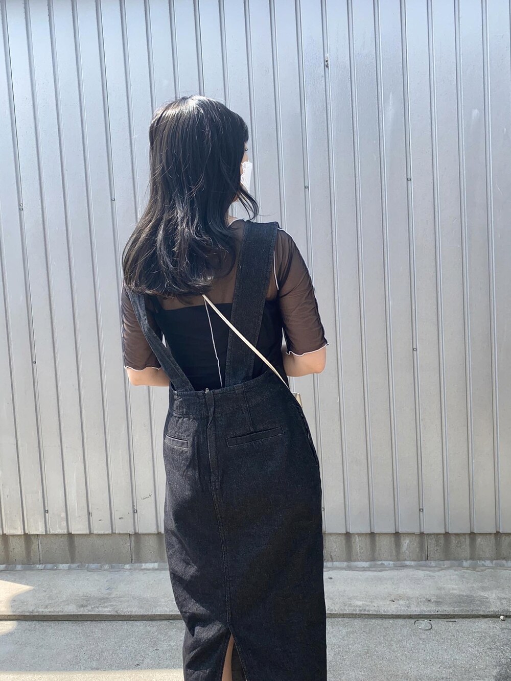 ホワイト系のショルダーバッグ、ブラック系のジャンパースカート、ブラック系のシャツ/ブラウスを着用したレディースの春コーディネートの3枚目の写真