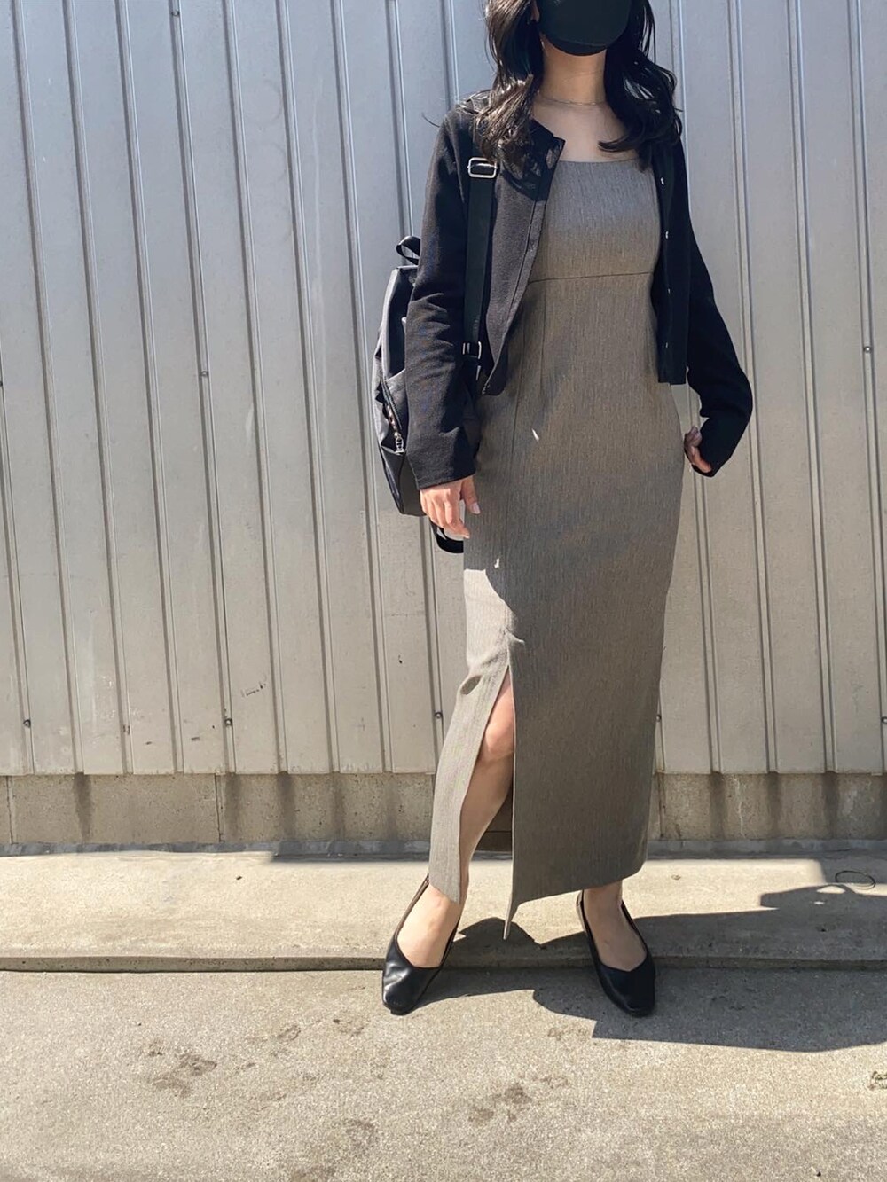 グレー系のワンピース、ブラック系のパンプス、ブラック系のバックパック/リュックを着用したレディースの春コーディネートの2枚目の写真