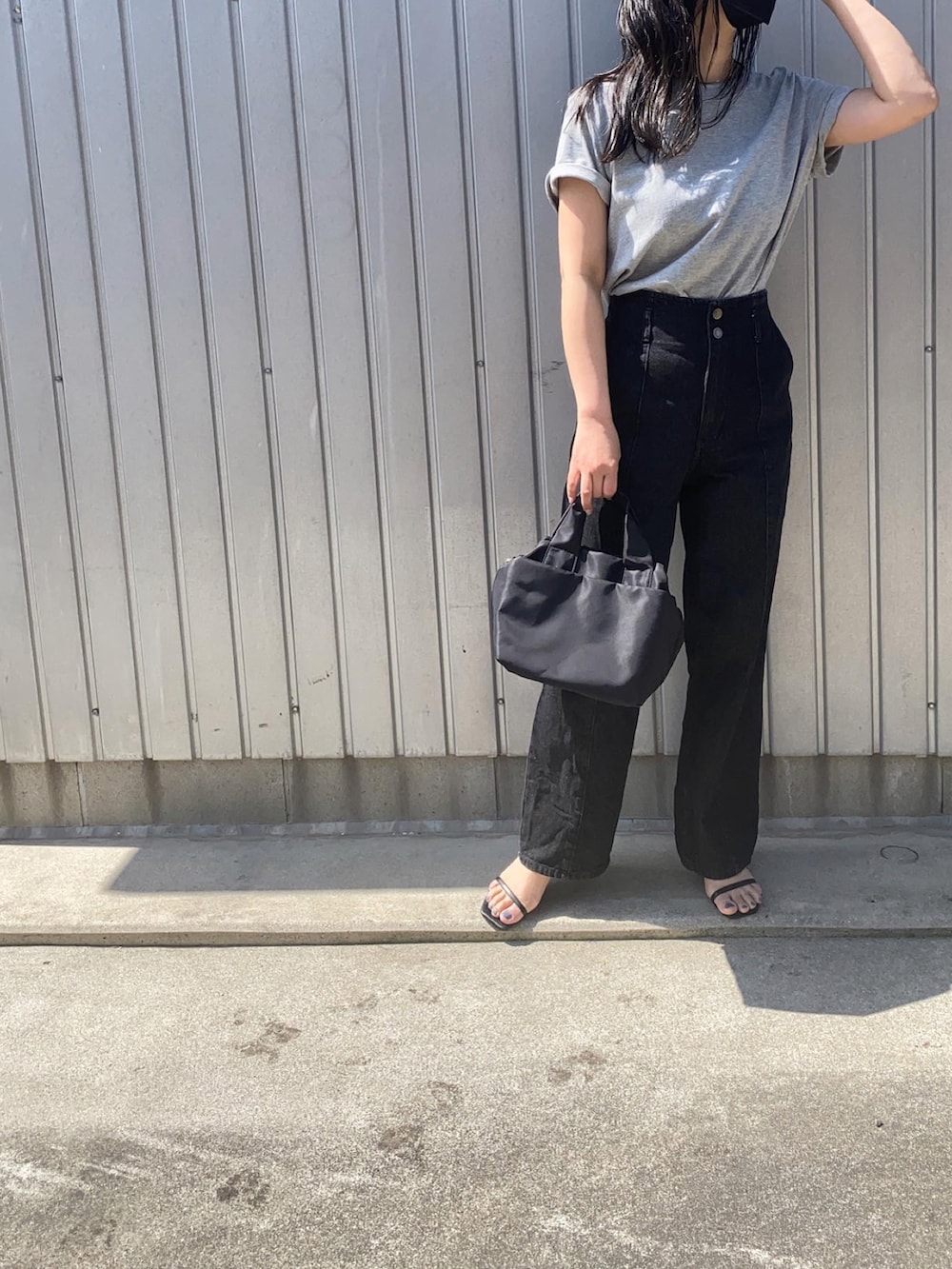グレー系のTシャツ/カットソー、ブラック系のデニムパンツ、ブラック系のハンドバッグを着用したレディースの春コーディネートの3枚目の写真