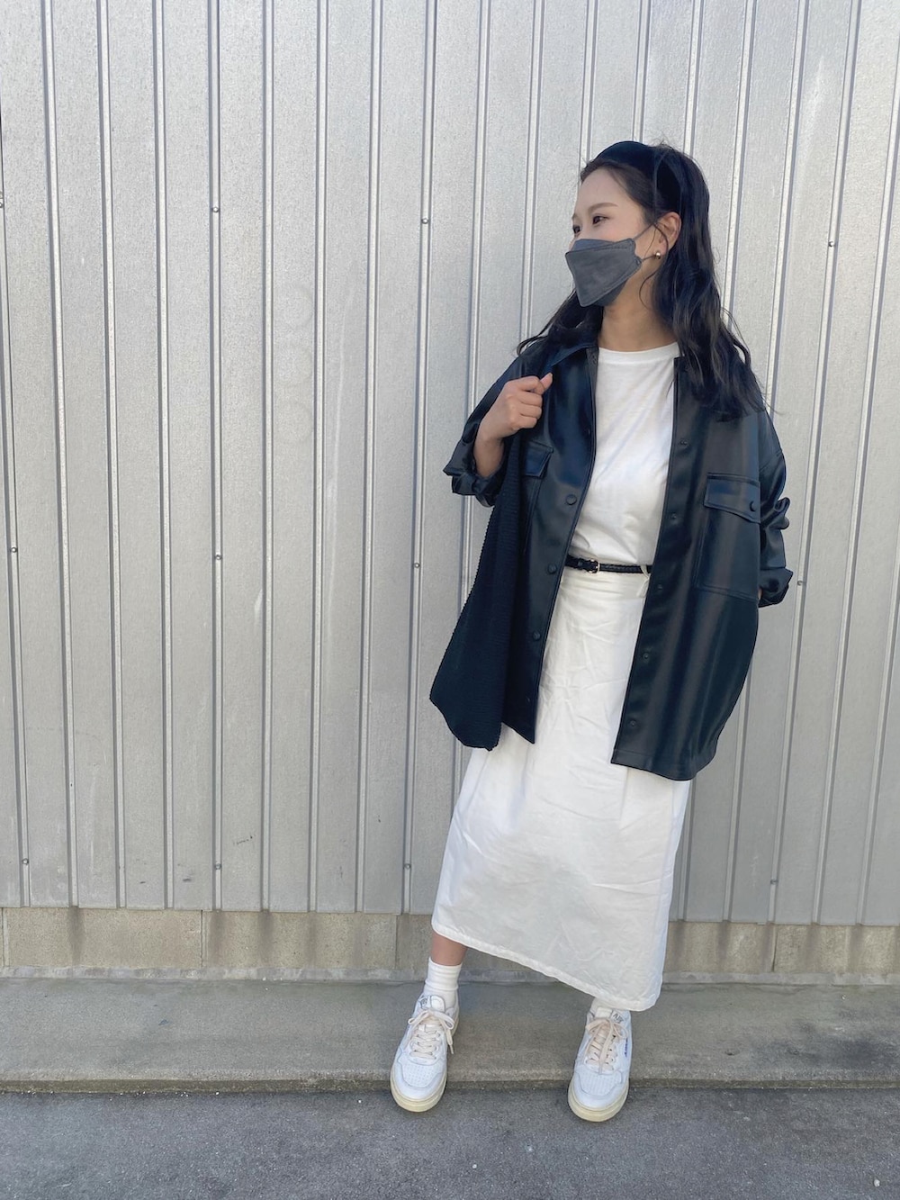 ブラック系のその他アウター、ブラック系のハンドバッグ、ホワイト系のスニーカーを着用したレディースの秋コーディネートの2枚目の写真