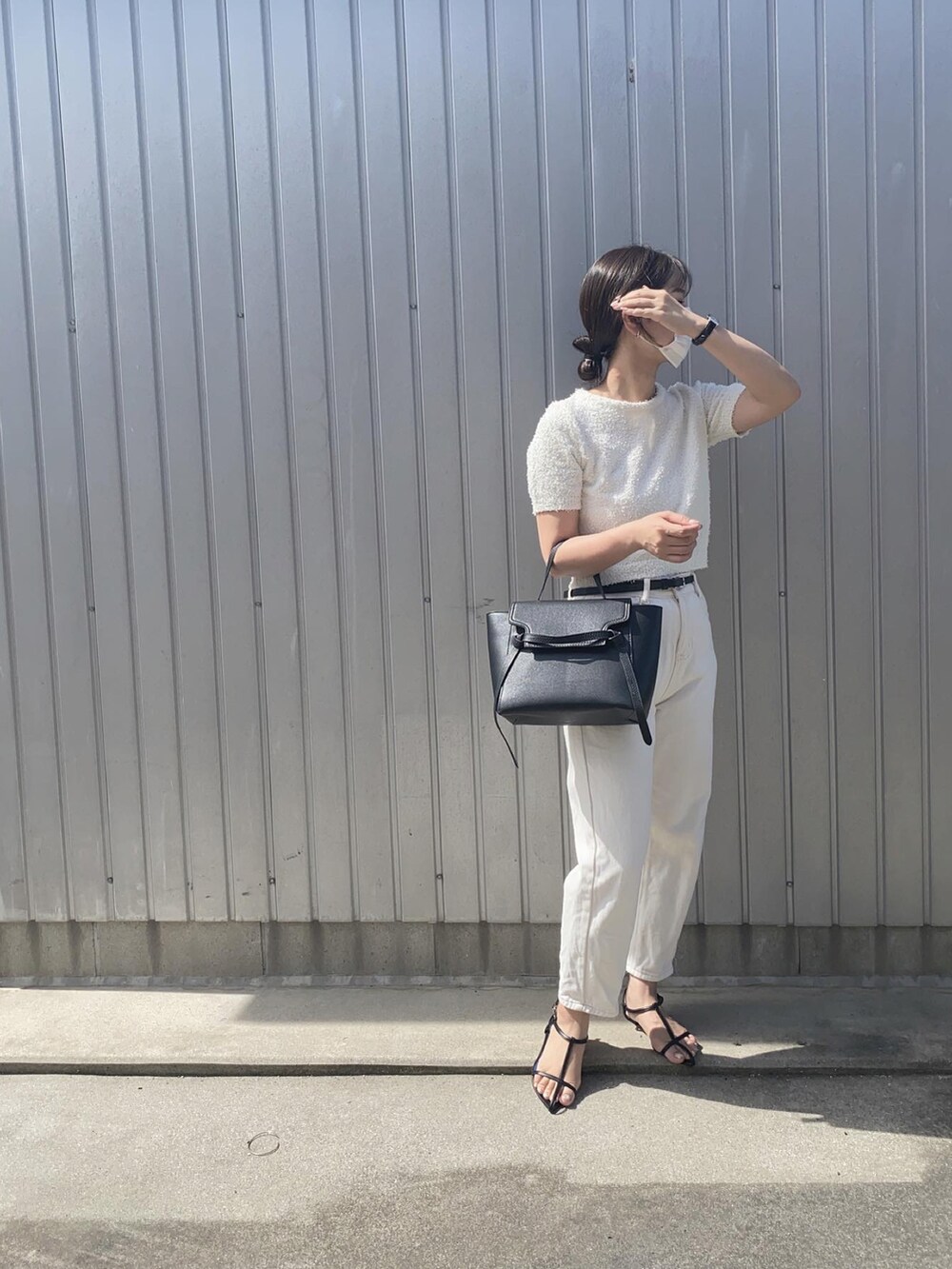 ブラック系のサンダル、ホワイト系のTシャツ/カットソー、ブラック系のアナログ腕時計を着用したレディースの夏コーディネートの2枚目の写真