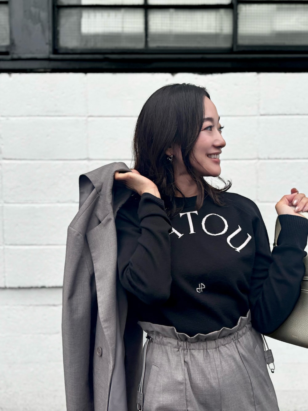 ブラック系のトップス、グレー系のジャケット/アウター、グレー系のパンツを着用したレディースの秋コーディネートの2枚目の写真