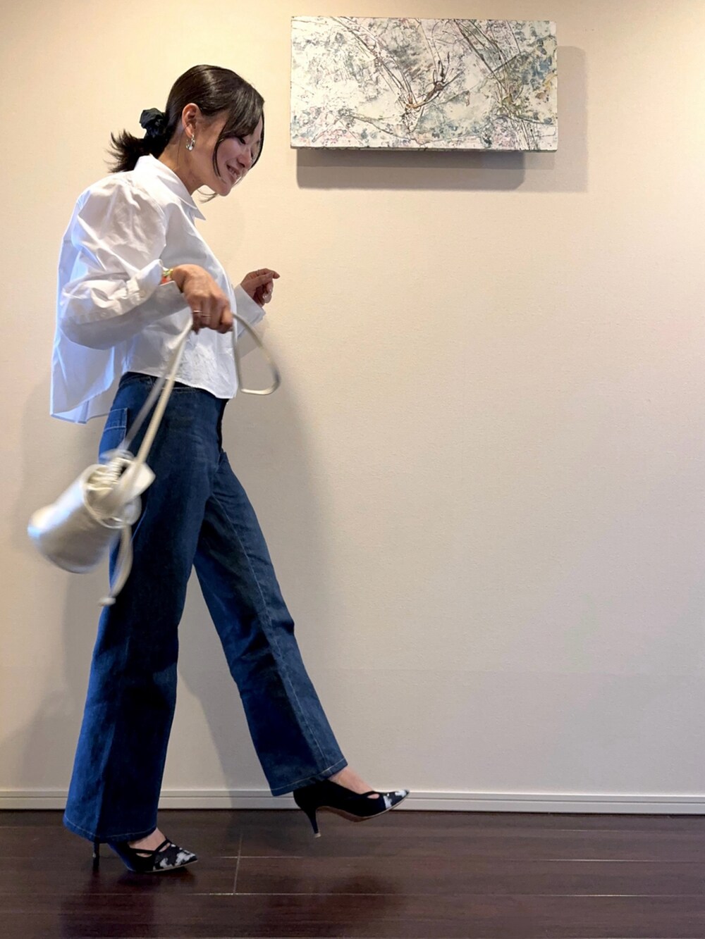 ブルー系のパンプス、ブルー系のデニムパンツ、ホワイト系のシャツ/ブラウスを着用したレディースの秋コーディネートの2枚目の写真