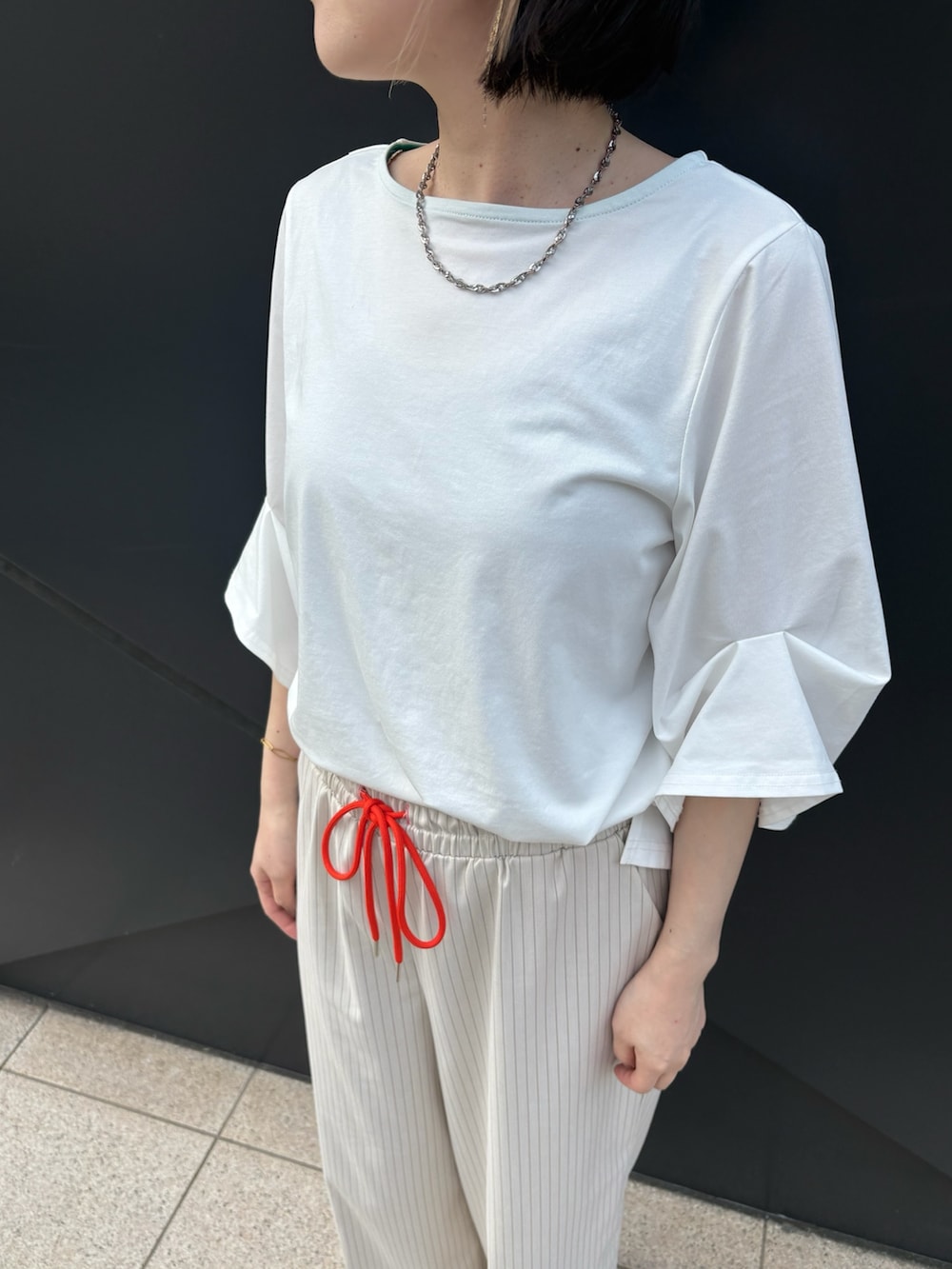 ホワイト系のTシャツ/カットソー、ホワイト系のブルゾン、ベージュ系のその他パンツを着用したレディースの春コーディネートの4枚目の写真