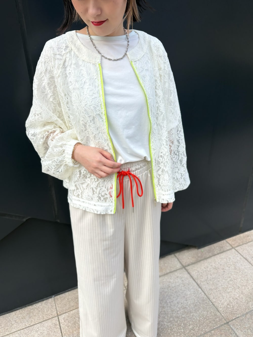 ホワイト系のTシャツ/カットソー、ホワイト系のブルゾン、ベージュ系のその他パンツを着用したレディースの春コーディネートの2枚目の写真