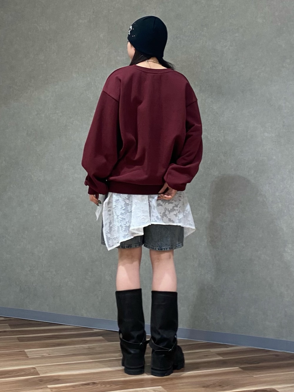 ホワイト系のスカート、ブルー系のデニムパンツ、ブラック系のブーツを着用したレディースの冬コーディネートの4枚目の写真