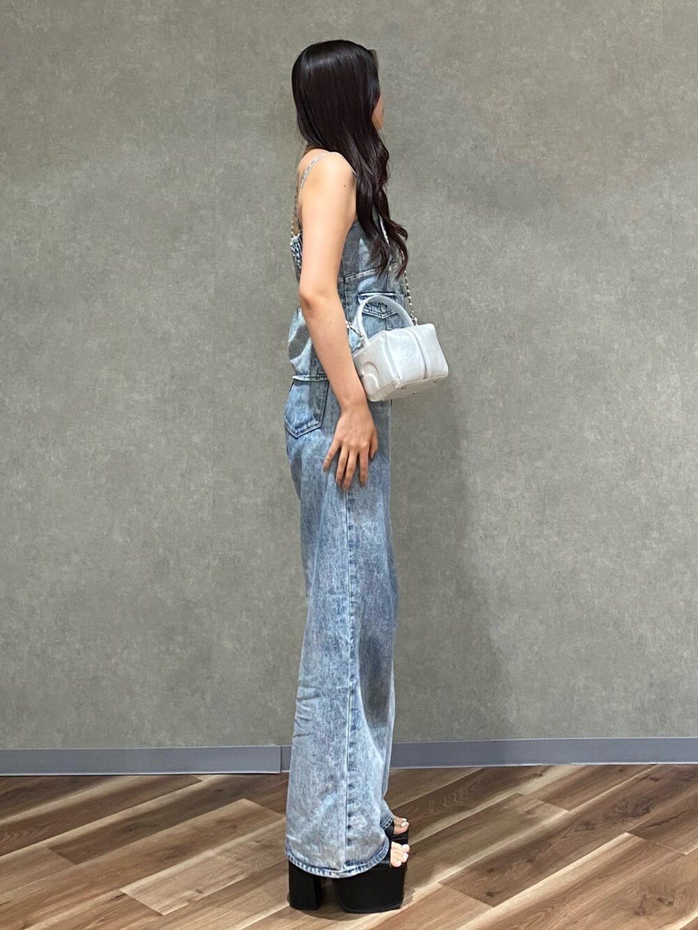 ブルー系のデニムパンツ、ブルー系のキャミソール、シルバー系のハンドバッグを着用したレディースの夏コーディネートの3枚目の写真