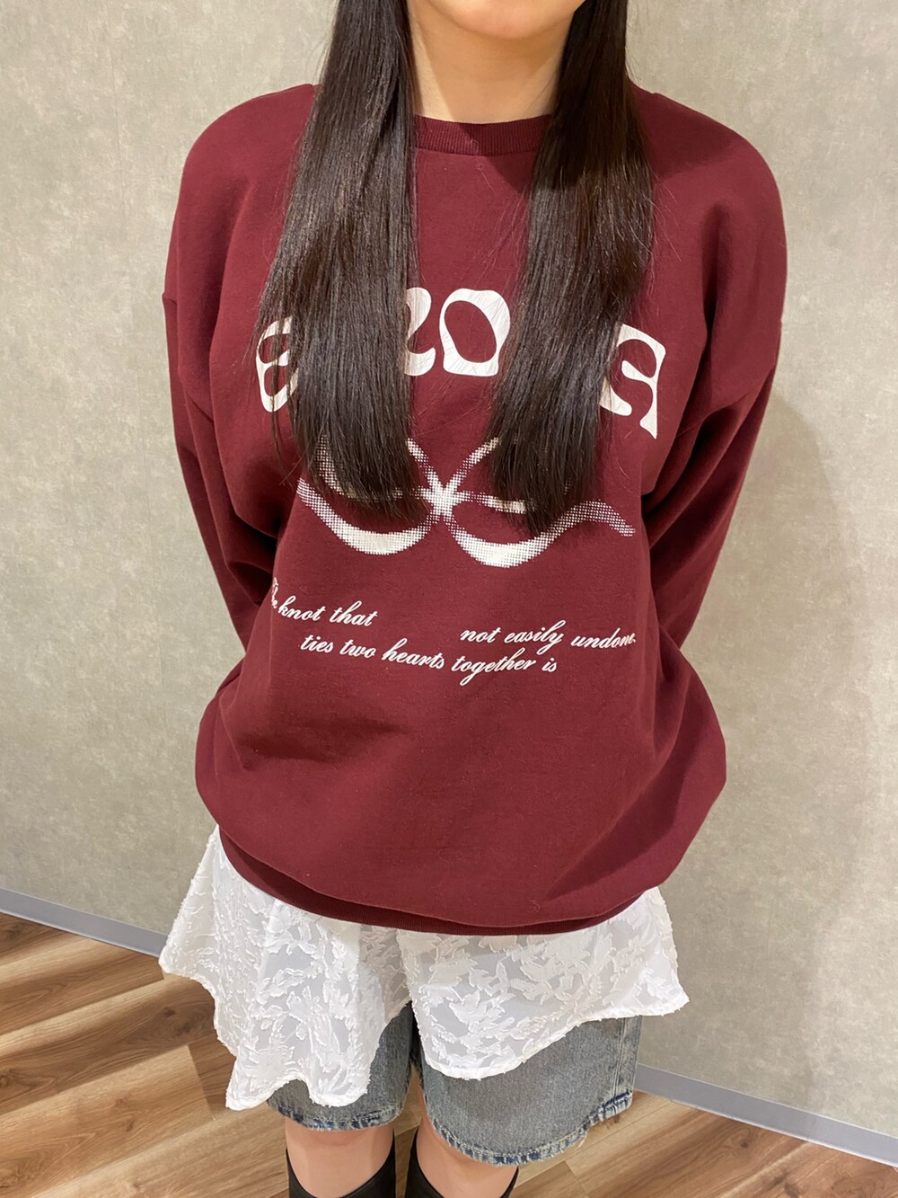 ホワイト系のスカート、ブルー系のデニムパンツ、ブラック系のブーツを着用したレディースの冬コーディネートの5枚目の写真