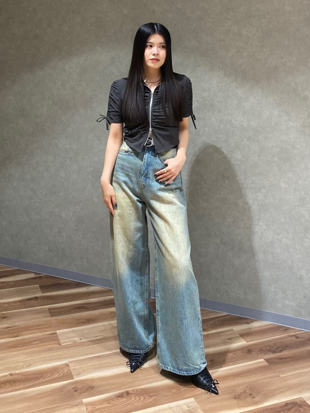 ブルー系のデニムパンツ、ブラック系のシャツ/ブラウス、ブラック系のパンプスを着用したレディースの春コーディネートの2枚目の写真