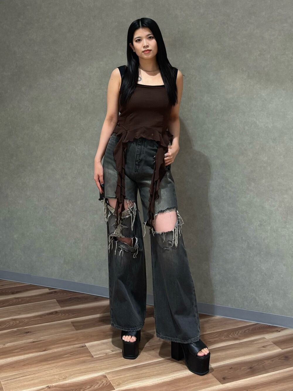 ブラック系のデニムパンツ、ブラック系のサンダル、ブラウン系のTシャツ/カットソーを着用したレディースの春コーディネートの2枚目の写真