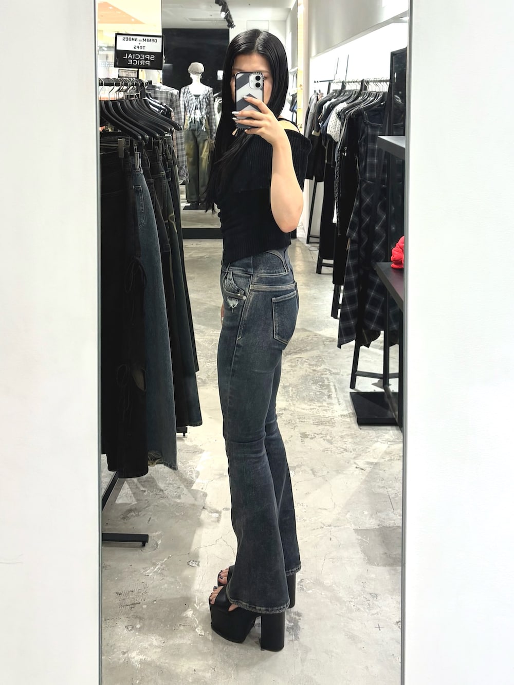 ブルー系のデニムパンツ、ブラック系のニット/セーター、ブラック系のサンダルを着用したレディースの夏コーディネートの2枚目の写真