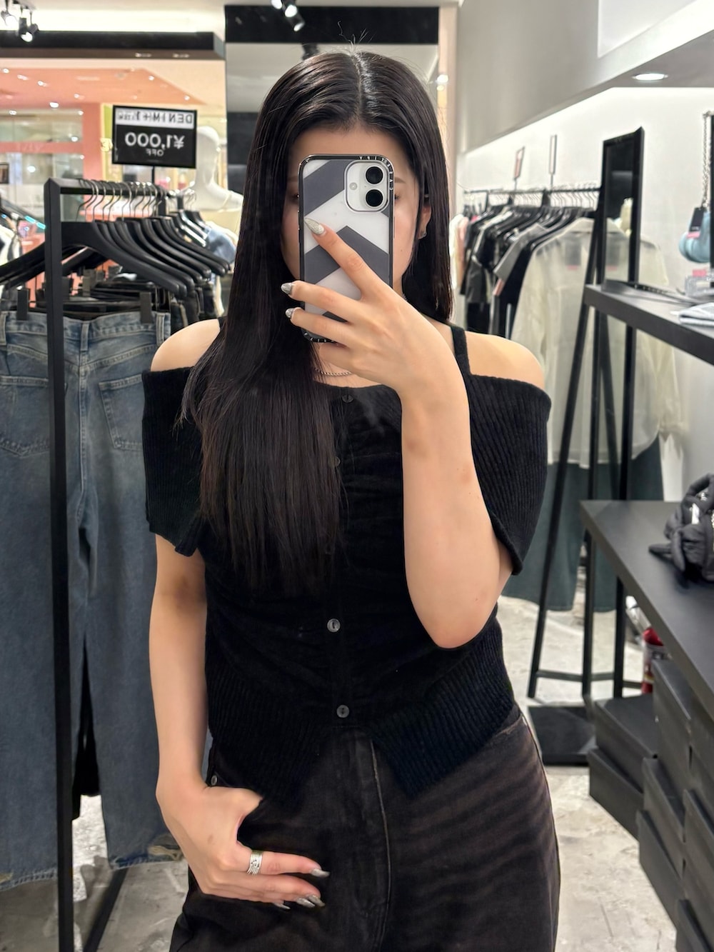 ブラック系のデニムパンツ、ブラック系のサンダル、ブラック系のニット/セーターを着用したレディースの夏コーディネートの4枚目の写真