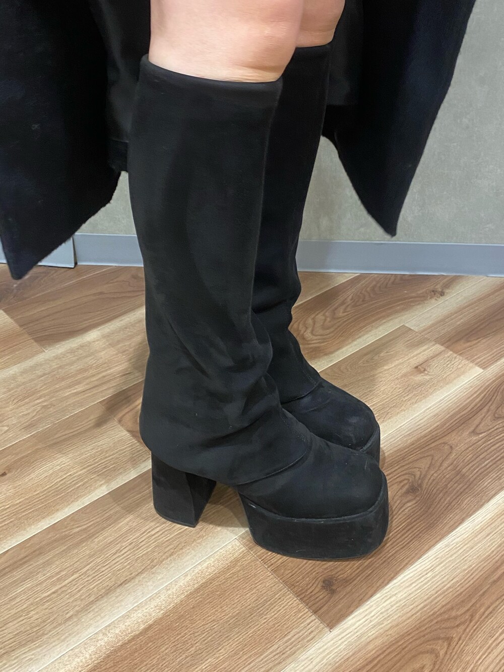 シルバー系のニット/セーター、ブラック系のブーツ、ブラック系のその他アウターを着用したレディースの冬コーディネートの7枚目の写真