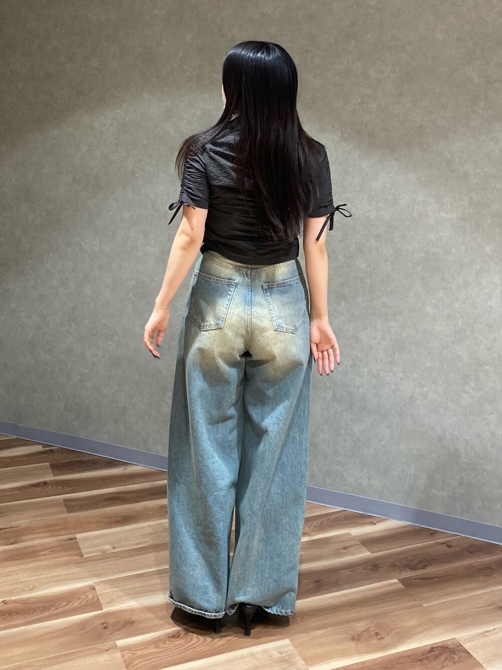 ブルー系のデニムパンツ、ブラック系のシャツ/ブラウス、ブラック系のパンプスを着用したレディースの春コーディネートの4枚目の写真