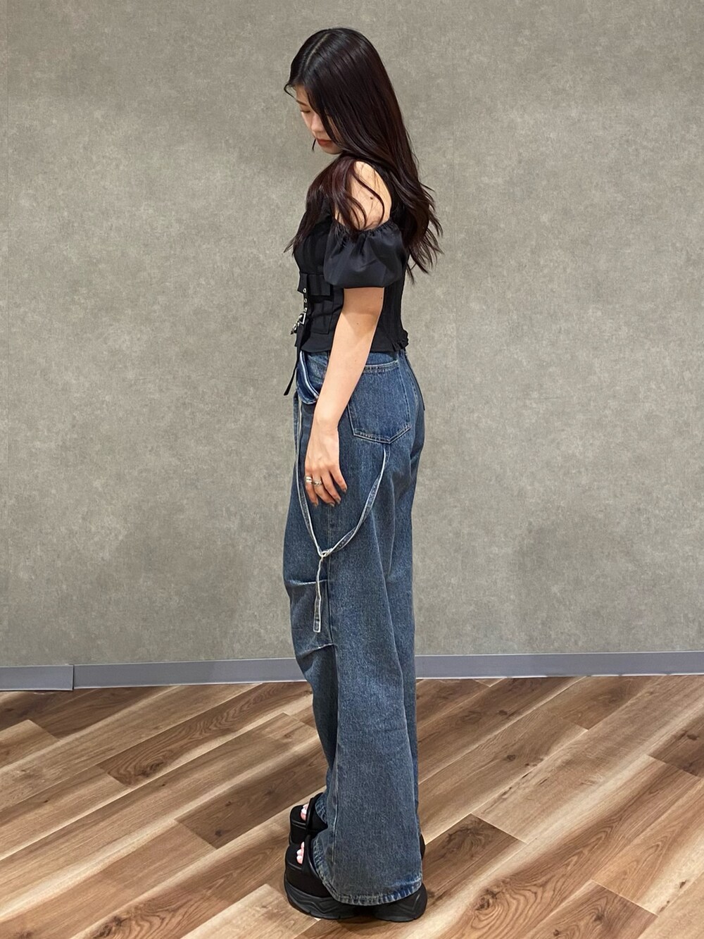 ブルー系のデニムパンツ、ブラック系のショルダーバッグ、ブラック系のTシャツ/カットソーを着用したレディースの夏コーディネートの3枚目の写真