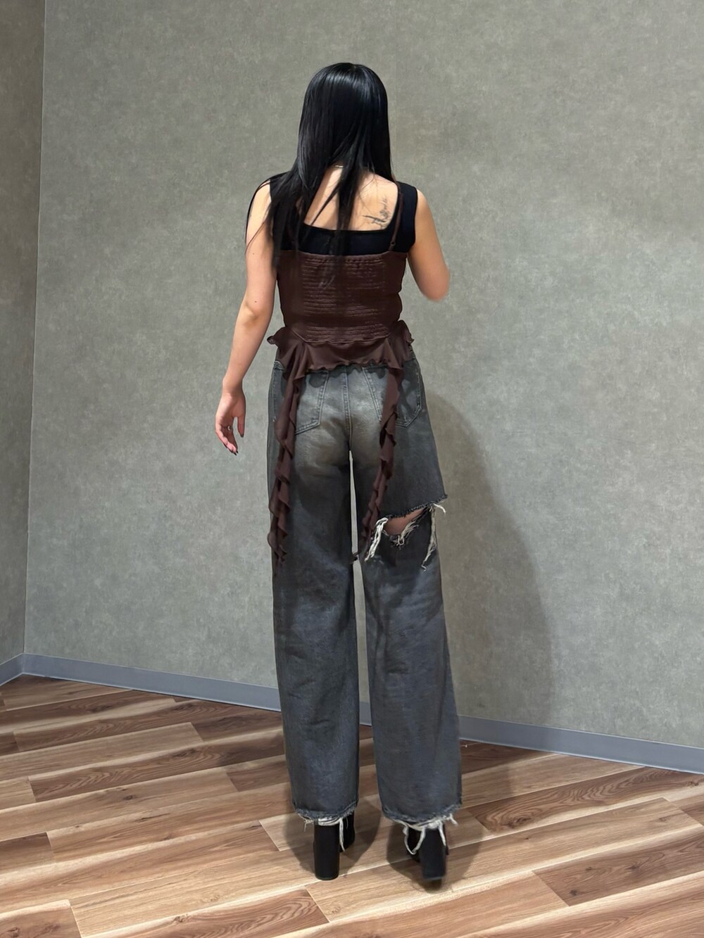 ブラック系のデニムパンツ、ブラック系のサンダル、ブラウン系のTシャツ/カットソーを着用したレディースの春コーディネートの4枚目の写真