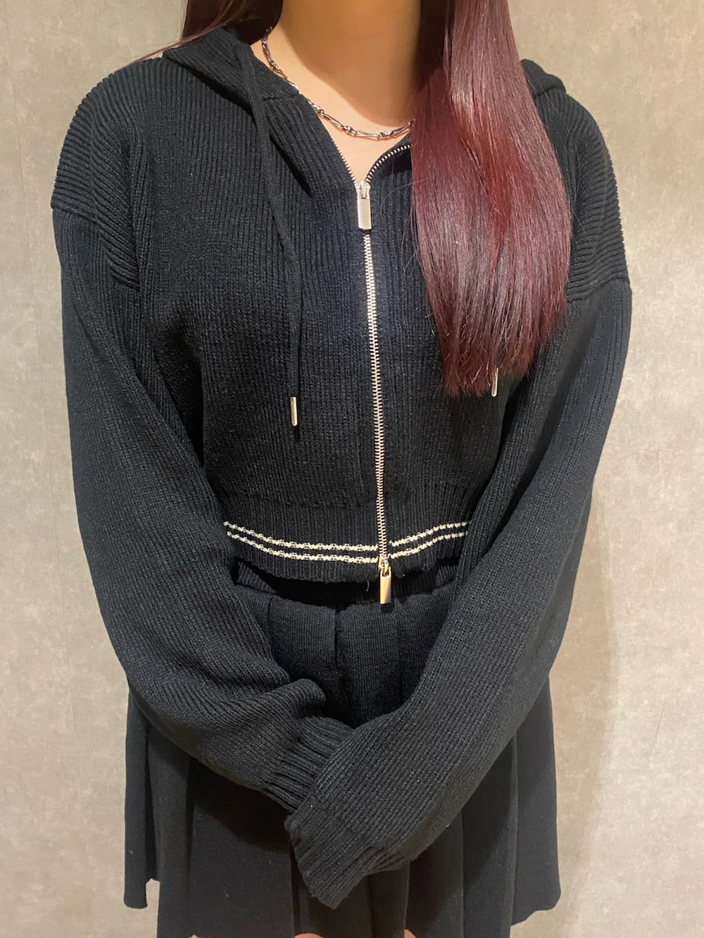 グレー系のブルゾン、ブラック系のニット/セーター、ブラック系のスカートを着用したレディースの秋コーディネートの6枚目の写真