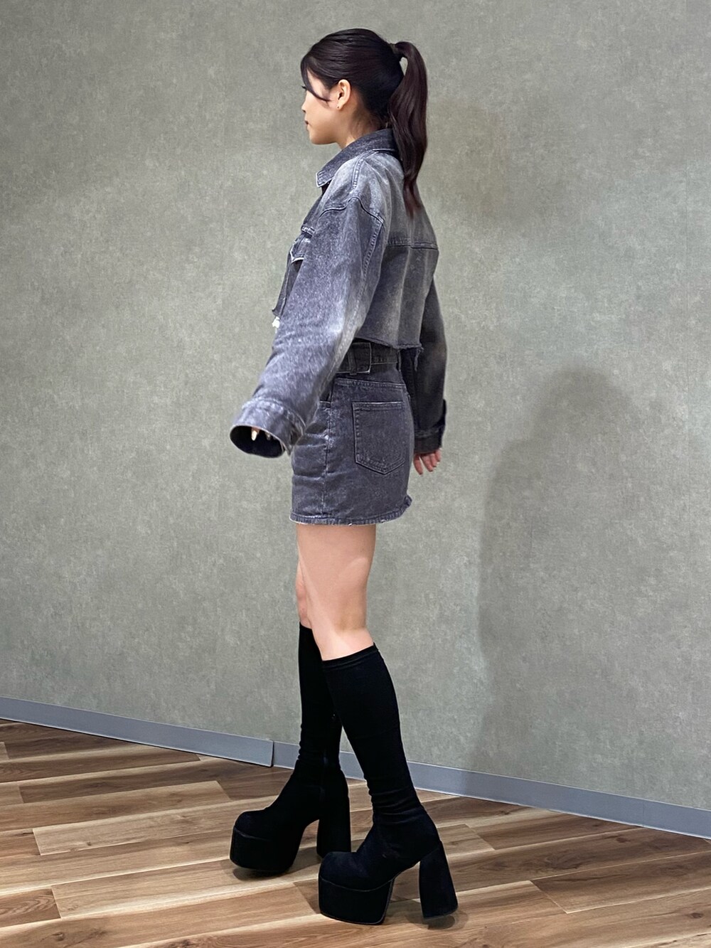 ブラック系のデニムジャケット、ホワイト系のニット/セーター、ブラック系のデニムスカートを着用したレディースの秋コーディネートの3枚目の写真