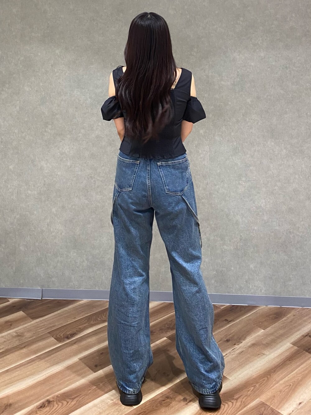 ブルー系のデニムパンツ、ブラック系のショルダーバッグ、ブラック系のTシャツ/カットソーを着用したレディースの夏コーディネートの4枚目の写真