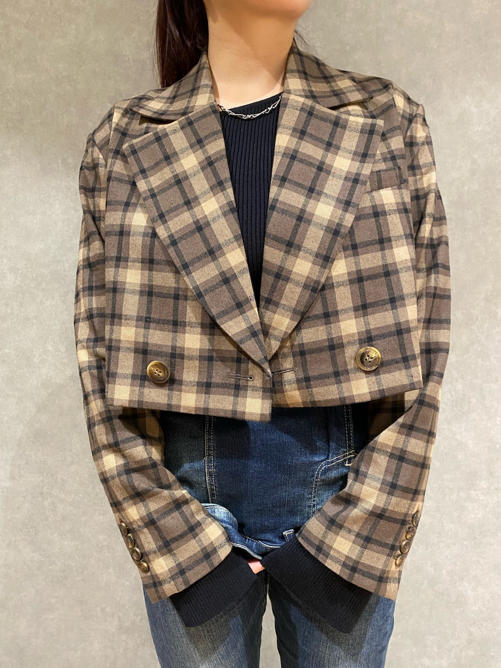 ブラック系のニット/セーター、ブルー系のデニムパンツ、ブラック系のブーツを着用したレディースの秋コーディネートの5枚目の写真