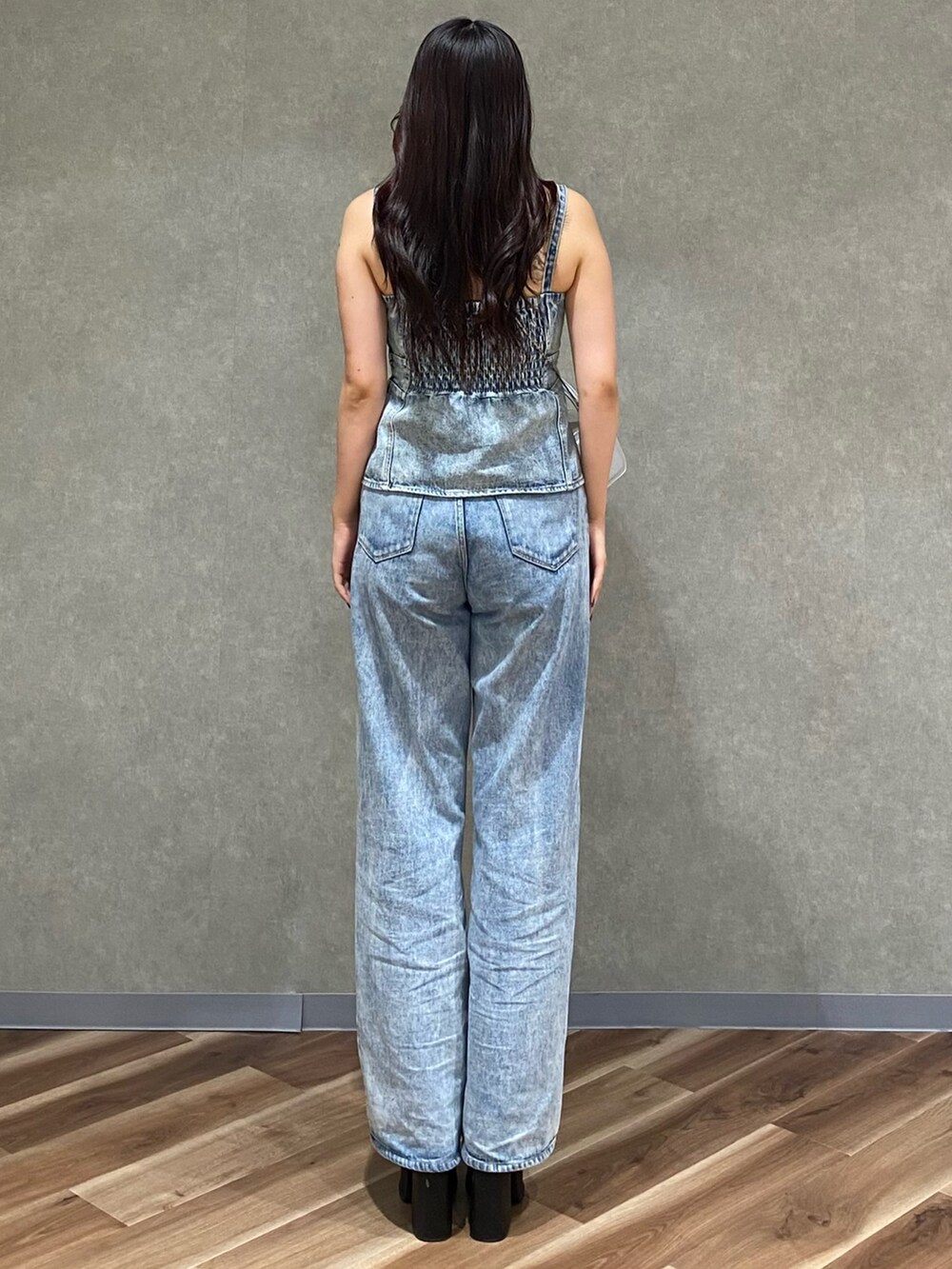 ブルー系のデニムパンツ、ブルー系のキャミソール、シルバー系のハンドバッグを着用したレディースの夏コーディネートの4枚目の写真