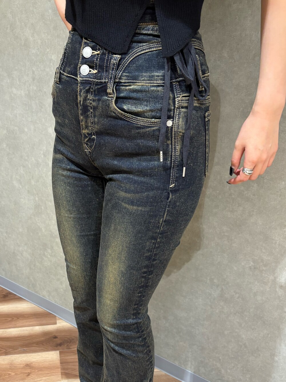 ブラック系のニット/セーター、ブルー系のデニムパンツ、ブラック系のサンダルを着用したレディースの春コーディネートの6枚目の写真