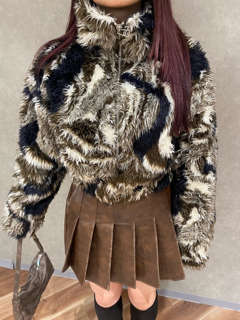 ブラウン系のスカート、ブラウン系のショルダーバッグ、ブラック系のブーツを着用したレディースの秋コーディネートの5枚目の写真