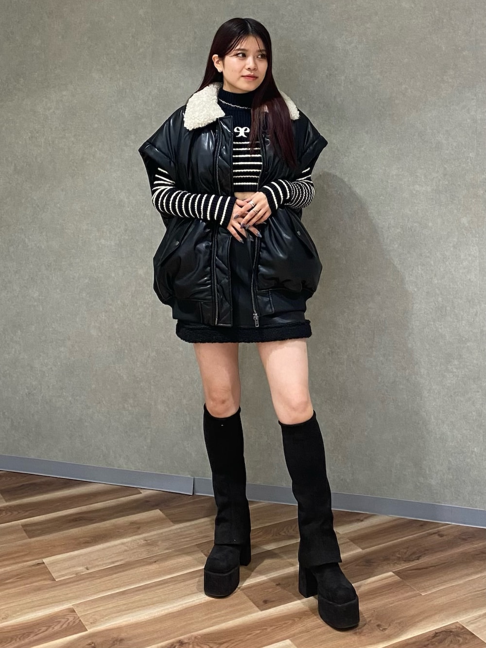 ブラック系のブルゾン、ブラック系のニット/セーター、ブラック系のスカートを着用したレディースの秋コーディネートの2枚目の写真