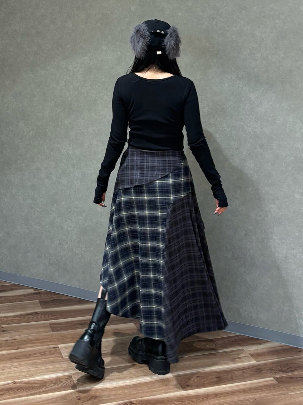 ブラック系のTシャツ/カットソー、ブルー系のスカート、ブラック系のブーツを着用したレディースの秋コーディネートの3枚目の写真