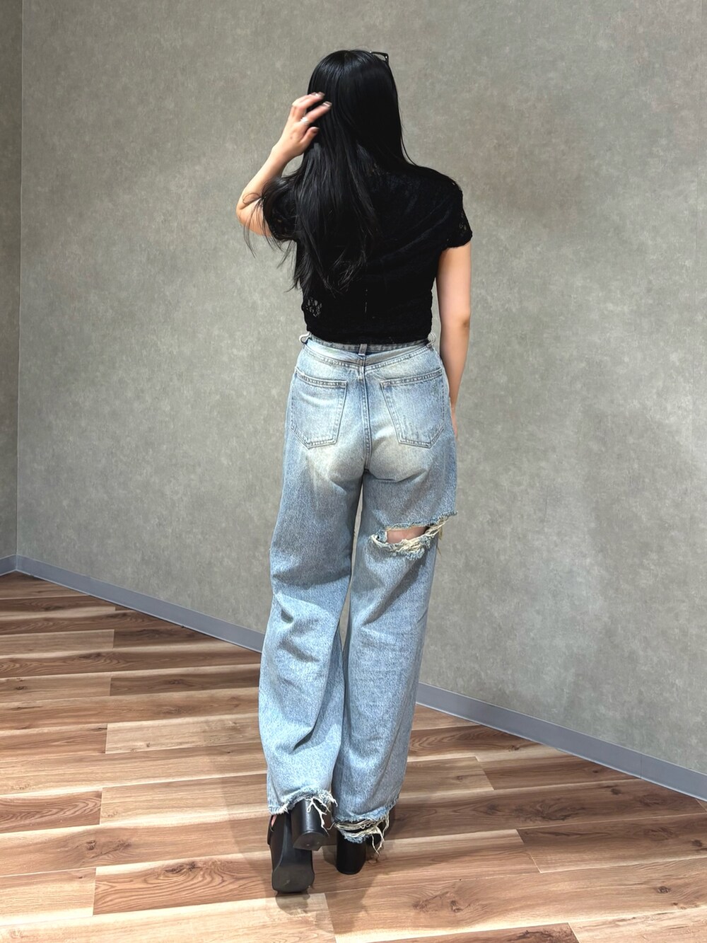 ブルー系のデニムパンツ、ブラック系のサンダル、ブラック系のTシャツ/カットソーを着用したレディースの夏コーディネートの4枚目の写真