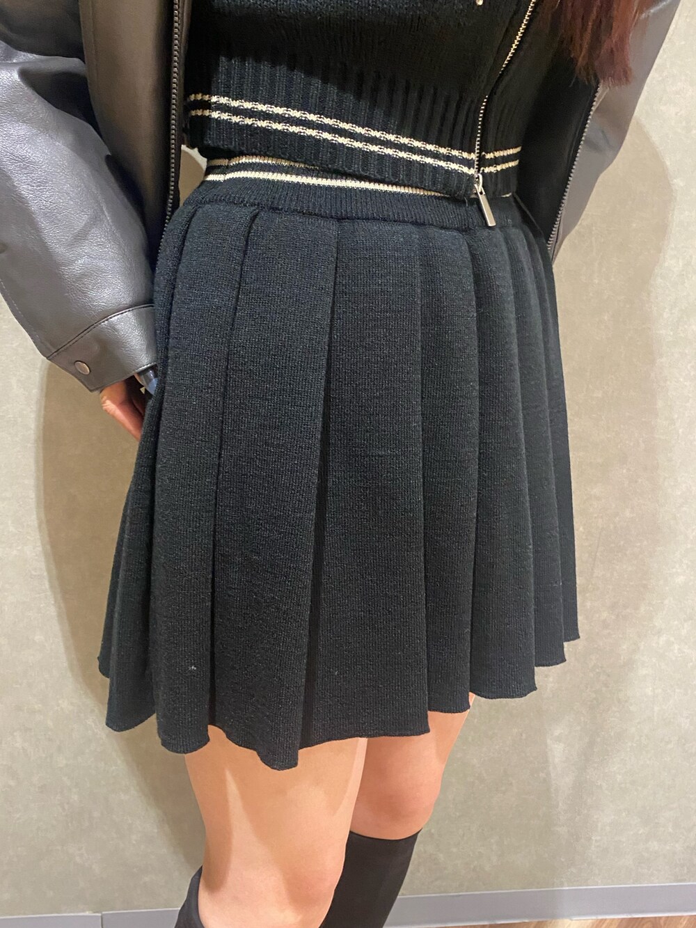 グレー系のブルゾン、ブラック系のニット/セーター、ブラック系のスカートを着用したレディースの秋コーディネートの7枚目の写真